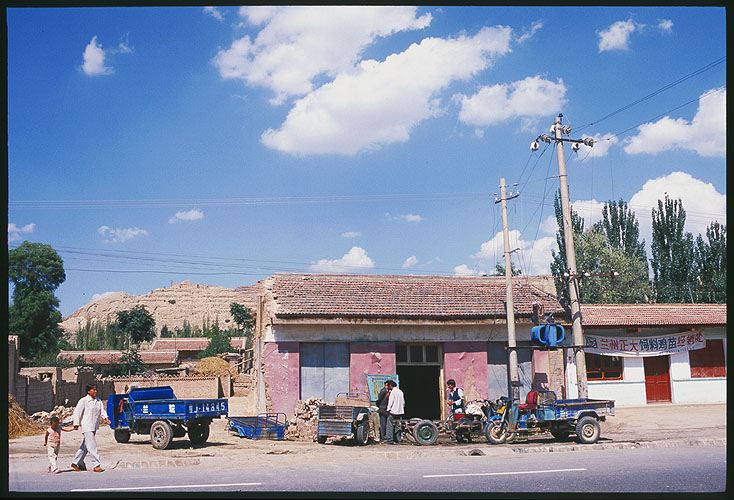 Dwellings and shops along the road<br>A Strip Village: Linxia to Lanzhou, Gansu, People's Republic of China
: Towns; Buildings.