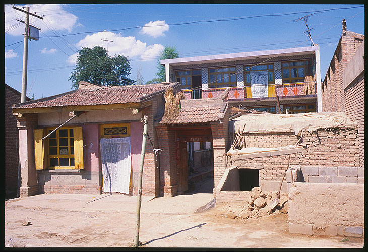 Dwellings and shops along the road<br>A Strip Village: Linxia to Lanzhou, Gansu, People's Republic of China
; Buildings.