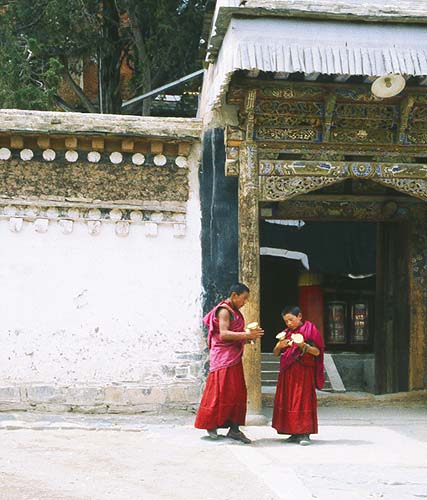 Two young monks delivering yak butter candles.: Xiahe -- Labrang Si, Gansu, People's Republic of China
: People You Meet.